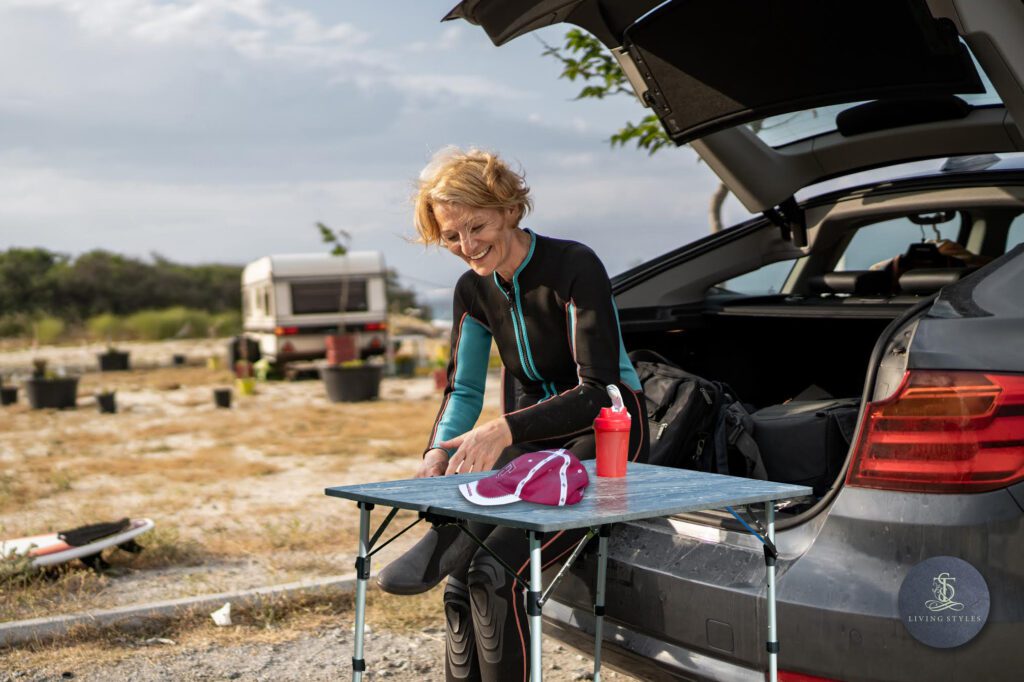 A woman sitting at the back of her car