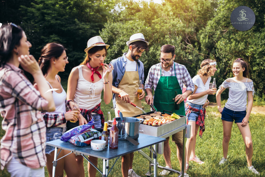 A group of people standing around a table with food.