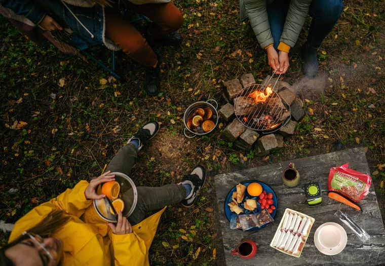 A group of people sitting around an open fire.