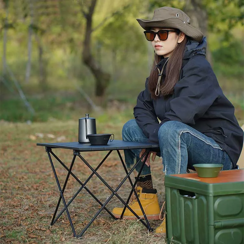 A woman sitting on the ground with an umbrella.